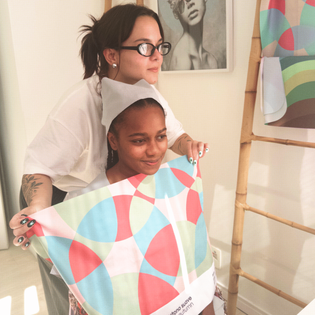 imagem granulada com duas mulheres. Uma delas, Beatriz, está fazendo um teste de coloração na outra pessoa.